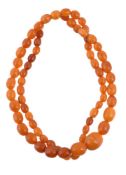 An amber bead necklace, the graduated oval amber beads measuring 8mm to 17mm, 26.6g gross, 69cm long