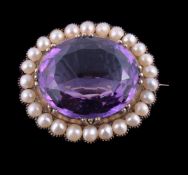 An Edwardian amethyst and half pearl brooch, the oval cut amethyst in a collet setting, within a