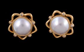 A pair of mabé pearl and diamond earrings, the circular mabé pearls within a pierced star shaped