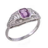 A pink sapphire and diamond ring, the tapering panel with a central step cut pink sapphire with