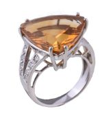 A citrine and diamond dress ring, the fancy cut citrine claw set between brilliant cut diamond set