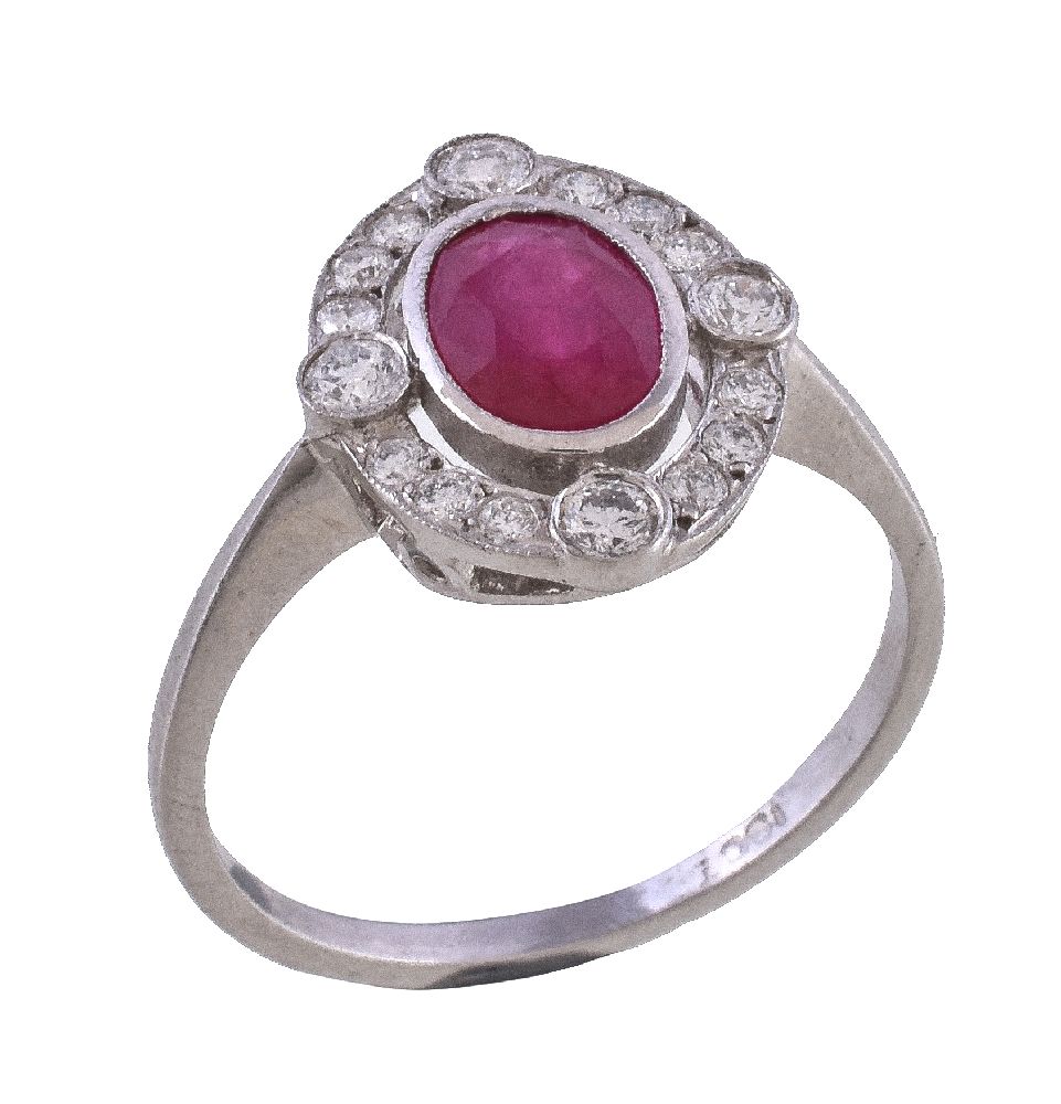 A ruby and diamond cluster ring, the oval cut ruby within a pierced surround of graduating brilliant