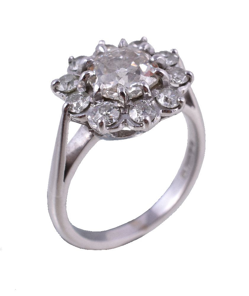 An 18 carat gold diamond cluster ring, the central old brilliant cut diamond estimated to weigh 1.18
