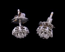 A pair of diamond cluster ear studs, the central brilliant cut diamonds set above smaller