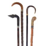 Four horn mounted walking sticks, all late 19th or early 20th century, the first handle carved as