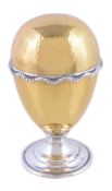 A hammered silver parcel gilt surprise Easter egg by David Rhys Mills, London 1996, opening to