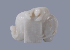 A Chinese white jade carving of and elephant, with brown inclusion to one side, with one figure on