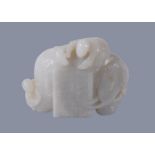 A Chinese white jade carving of and elephant, with brown inclusion to one side, with one figure on