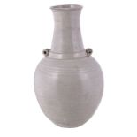 A Chinese white glazed bottle vase, Yuan Dynasty, the ovoid body with twin lug handles and everted