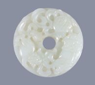 A Chinese white jade 'Buddhist Lion' disc, bi, of even pale tone, carved with two lions chasing a