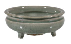 A Chinese celadon tripod censer, Ming Dynasty, with crazed pale-green glaze and raised on tapering