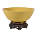 A Chinese yellow-glazed bowl, with deep rounded sides rising from a very short foot ring to a