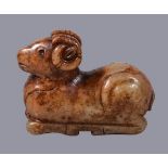 A Chinese celadon and russet jade figure of a ram, recumbent, with head looking forwards and its