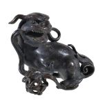 A small Chinese bronze Buddhist lion, Ming Dynasty, cast with the right forepaw resting on a