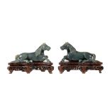 A pair of Chinese spinach jade models of recumbent horses, facing to the left and right, with carved