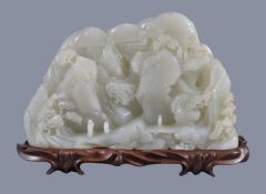 A large white jade 'landscape' boulder carving, of irregular shape, carved on one side in varying