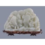 A large white jade 'landscape' boulder carving, of irregular shape, carved on one side in varying