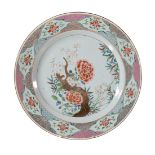 A large pair of Chinese Famille Rose plates, Qianlong, each painted to the centre with a flowering