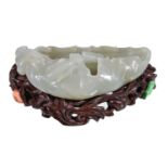 A Chinese white jade brush washer, with minor russet inclusions, carved in the form of a lotus leaf,