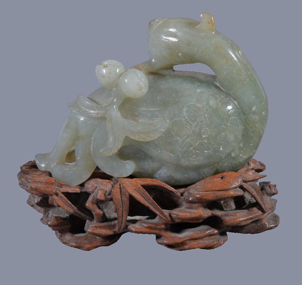 A Chinese jade or jadeite figure of a Phoenix, holding a peach branch, the jadeite 10.5cm wide x 7.