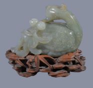 A Chinese jade or jadeite figure of a Phoenix, holding a peach branch, the jadeite 10.5cm wide x 7.