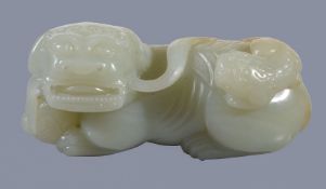 A Chinese celadon and russet jade 'lion and cub' carving, Qing Dynasty, the recumbent Buddhist