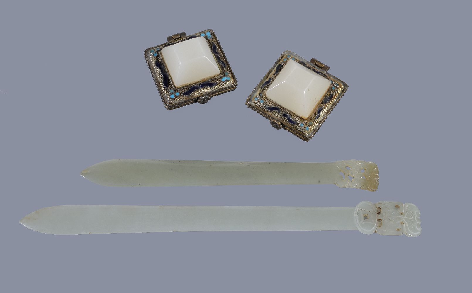 Two Chinese pale celadon jade hair pins, each of thin, curving section and spatulate form surmounted