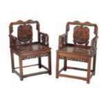 A pair of Chinese hardwood chairs, late Qing Dynasty, the shaped rectangular backs centred