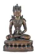 Y A Tibetan bronze figure of Buddha, seated in padmasana on a double lotus throne holding a fruit
