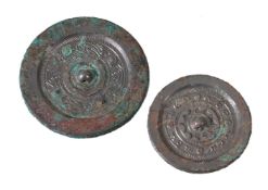 Two Chinese bronze mirrors, Han Dynasty, the smaller mirror with the pierced central knop