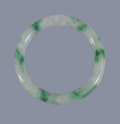 A Chinese jadeite bangle, the cylindrical jadeite band of pale green and cloudy white tone, suffused