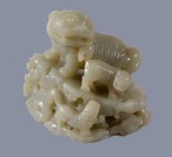A Chinese celadon jade carving of a Buddhist 'lion and cubs', standing on a pierced and openwork