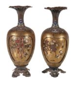 A pair of silver and gold lacquer vases, the ovoid body resting on a silver foot in the form of four