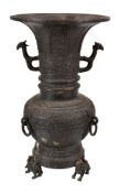 A Chinese bronze archaistic vase, zun, the central ovoid body wth mask and ring handles, the