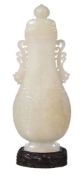 A Chinese white jade vase and cover, of even tone, the elegant flattened form, carved in archaic