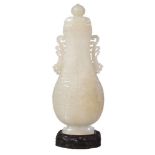 A Chinese white jade vase and cover, of even tone, the elegant flattened form, carved in archaic