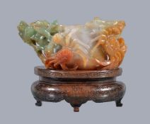 A Chinese jadeite water pot, the mottled white jade body with green and brown inclusions, on one