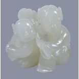 A small white jade group of a mother and child, both seated with the child holding a ruyi sceptre,