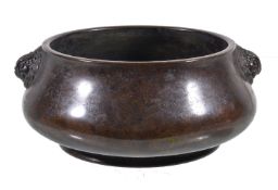 A Chinese bronze censer, with a mottled brown patina, of squat bulbous shape, with opposing grinning