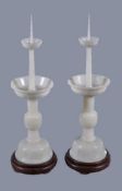 A pair of Chinese white jade candlesticks, each well carved in the form of a tapering cylinder