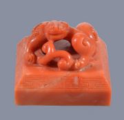 Y A rare Chinese coral 'chilong' seal, Qing Dynasty, of square form, surmounted by an openwork