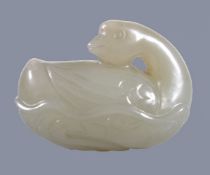 A Chinese pale celadon carving of a Goose, the base formed as a lotus leaf, with head tuned back,