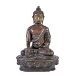 A Tibetan bronze figure of Buddha, seated in padmasana on a lotus throne, his right hand in