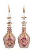 A pair of Bohemian/Czech clear, ruby-flashed and enamelled glass large bottles and spire stoppers