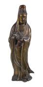 A Chinese gilt-bronze figure of Guanyin, standing holding a scroll, traces of gilding, 26cm high