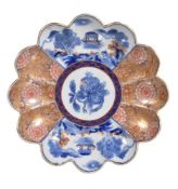 A Japanese Arita lobed shallow dish, decorated in under glaze blue enamels and gilding with stylised