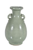 A Chinese celadon vase, with two mask and ring handles and with incised and carved foliage, the base