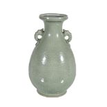 A Chinese celadon vase, with two mask and ring handles and with incised and carved foliage, the base