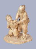 Y A Japanese Ivory Okimono, of a father standing beside his son as he helps him on with his hapi