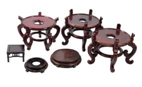 Six various Chinese wood stands, 20th century, comprising a large circular pair supported on five
